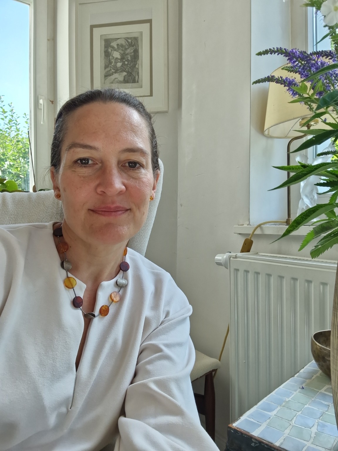 Dr. med. Constance Raimer mit Blumen im Praxisraum